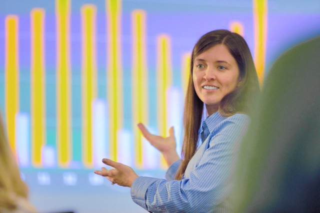 Nicole presenting in front of projection screen with a graph